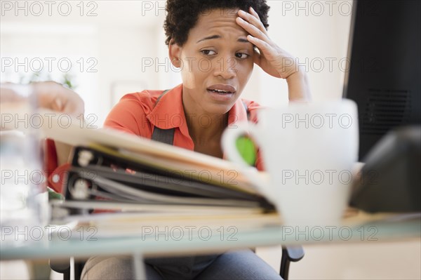 Frustrated African American woman sitting at desk