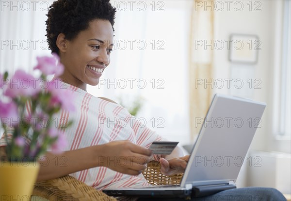 African American woman shopping online with credit card