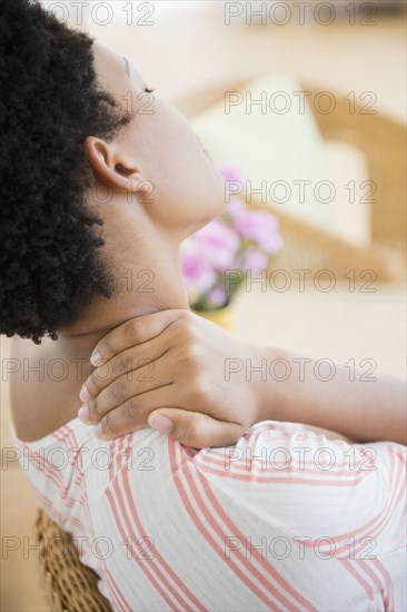 African American woman rubbing sore neck