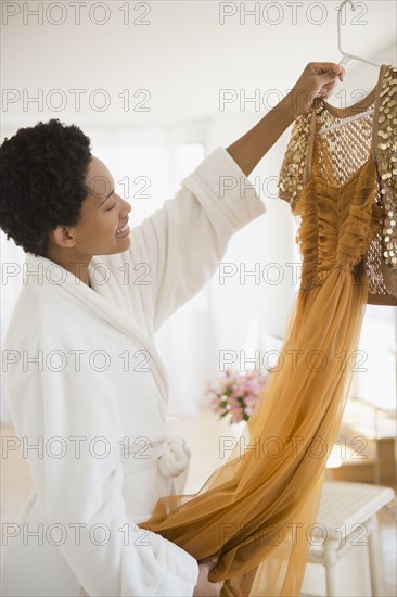 African American woman holding up glamorous dress