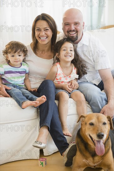 Smiling family sitting on sofa