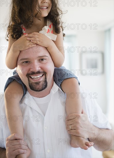 Father carrying daughter on shoulders