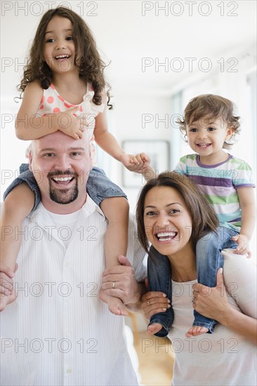 Parents carrying children on shoulders