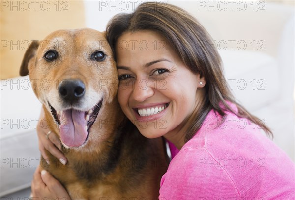 Hispanic woman hugging dog