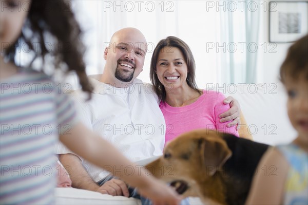 Mother and father watching children and dog