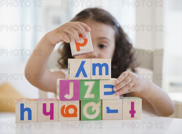 Mixed race girl stacking blocks