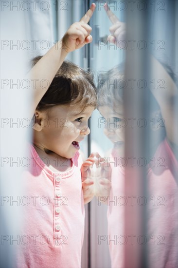 Mixed race girl looking out window