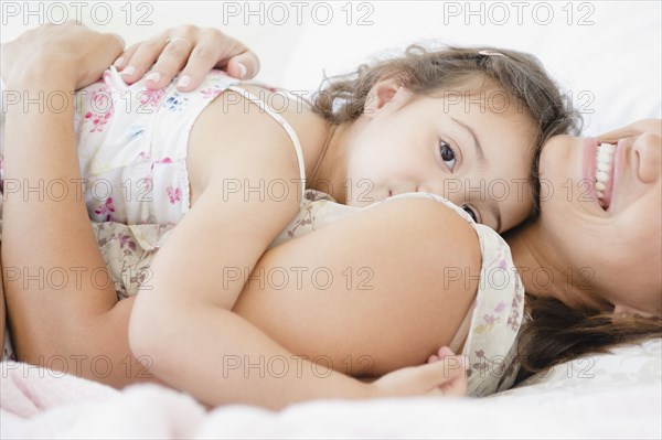 Mother and daughter laying on bed