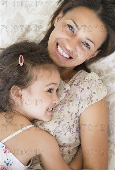 Mother and daughter laying on bed