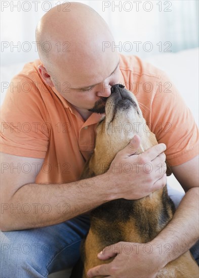 Man hugging and kissing dog