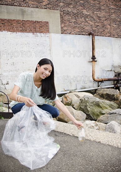 Asian woman picking up litter