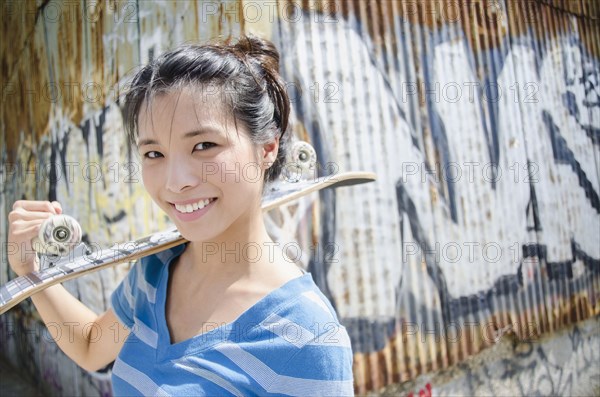 Asian woman carrying skateboard