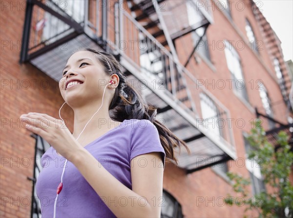 Asian woman jogging and listening to music