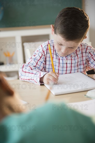 Caucasian boy writing in notebook