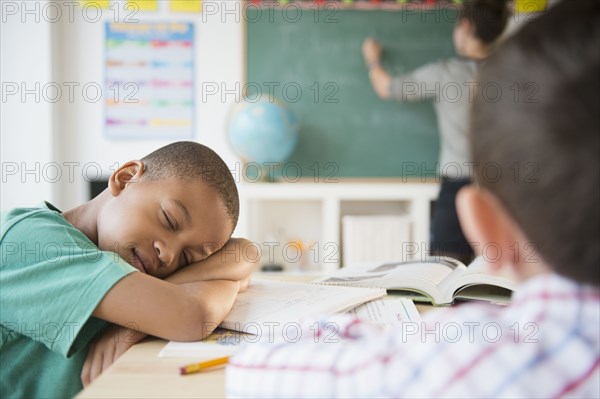 African American boy sleeping in classroom