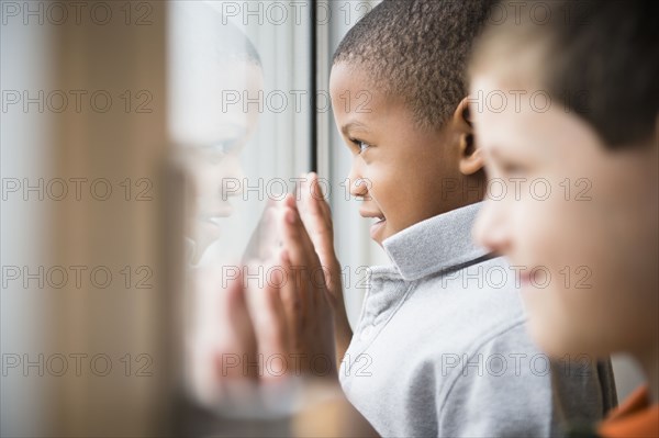 Boys looking out window together