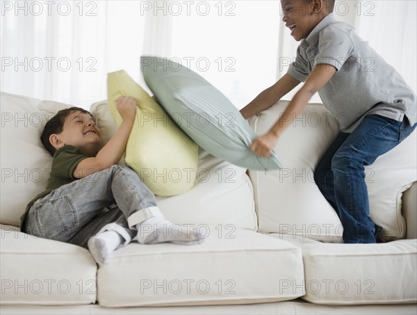 Boys rough housing on sofa