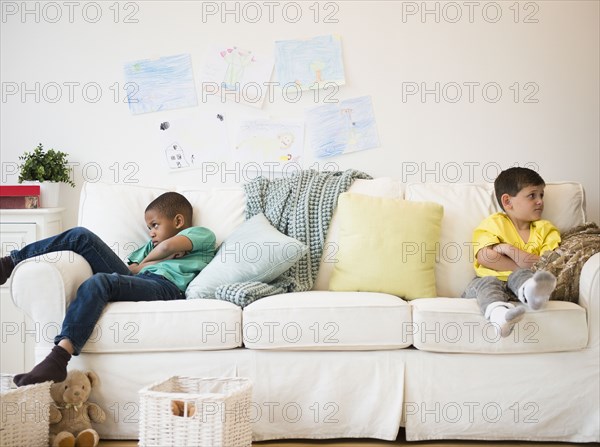 Angry boys sitting on sofa