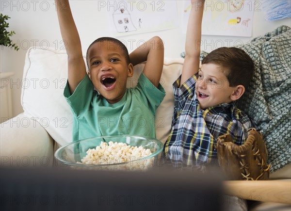 Boys eating popcorn and cheering