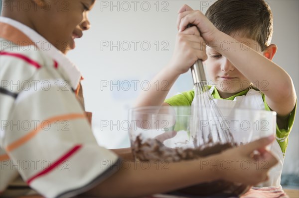 Boys mixing cake batter together