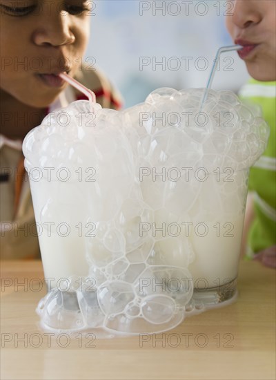 Boys blowing bubbles with milk together