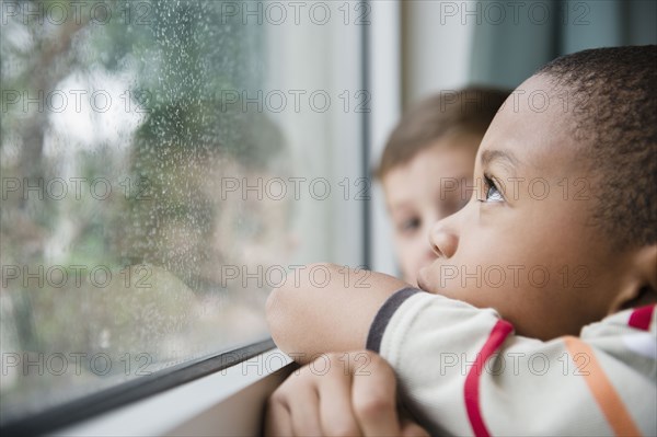 Boys looking out window together