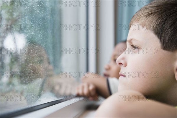 Boys looking out window together