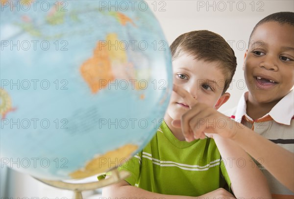 Boys looking at globe together