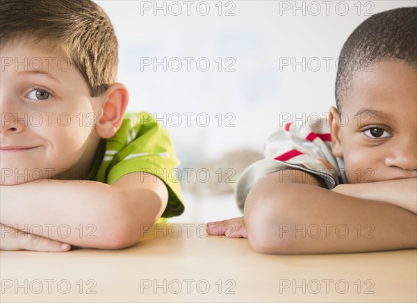 Bored boys leaning on table