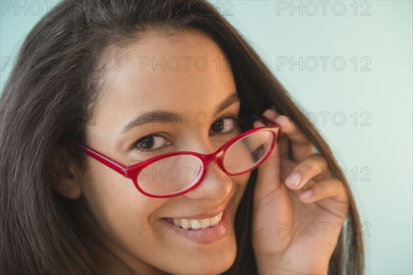 Hispanic teenager in red eyeglasses