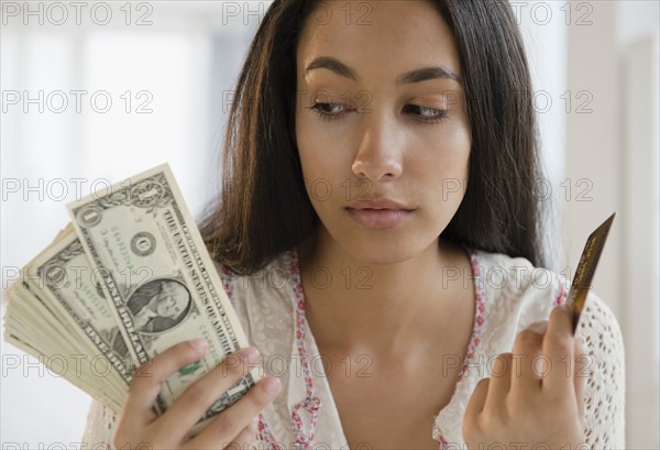 Hispanic teenager holding credit cards and money