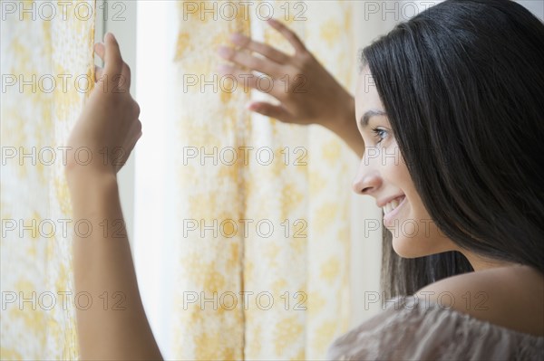 Hispanic teenager looking out window