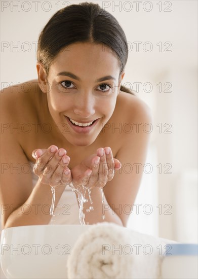 Hispanic teenager washing her face