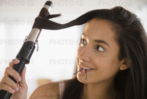 Hispanic teenager curing her hair