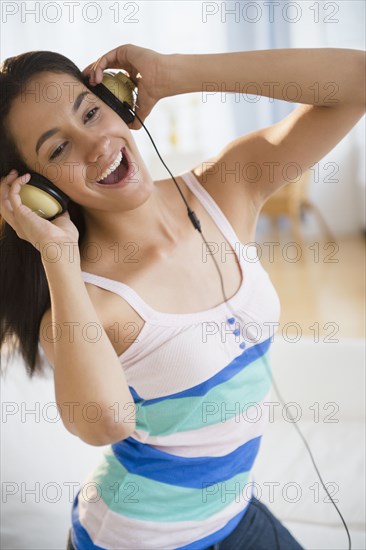 Hispanic teenager listening to music on headphones