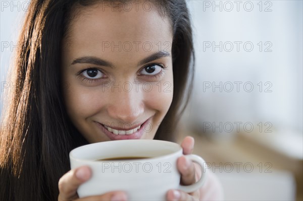 Hispanic teenager drinking coffee