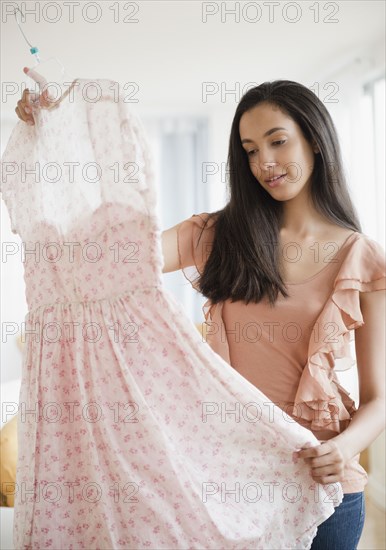 Hispanic teenager looking at dress