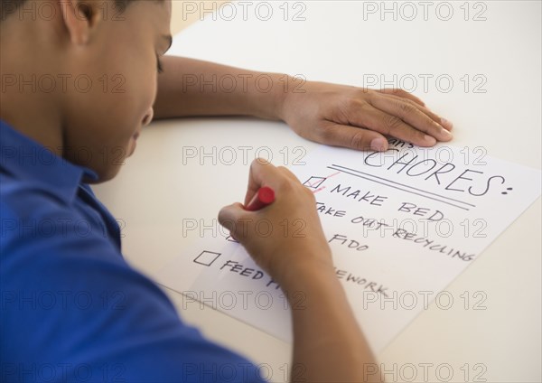 Hispanic boy checking off chore list