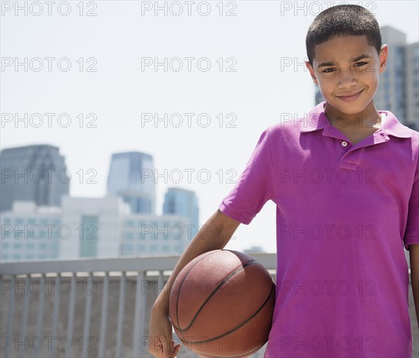 Hispanic boy holding basketball