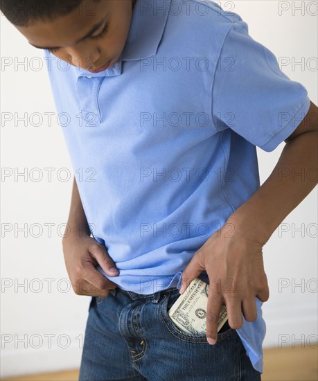 Hispanic boy putting in pocket