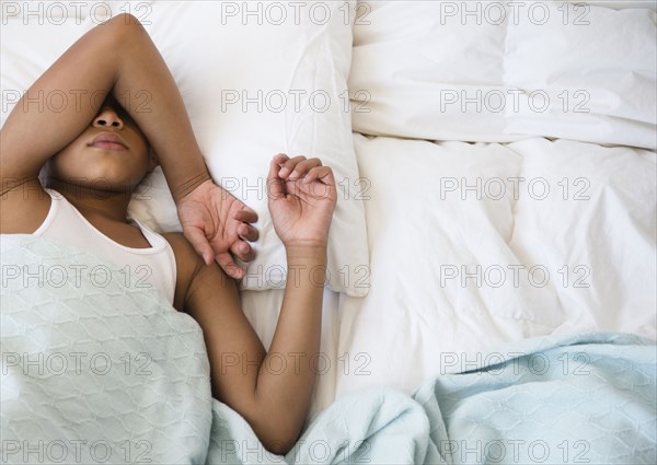 Hispanic boy laying in bed