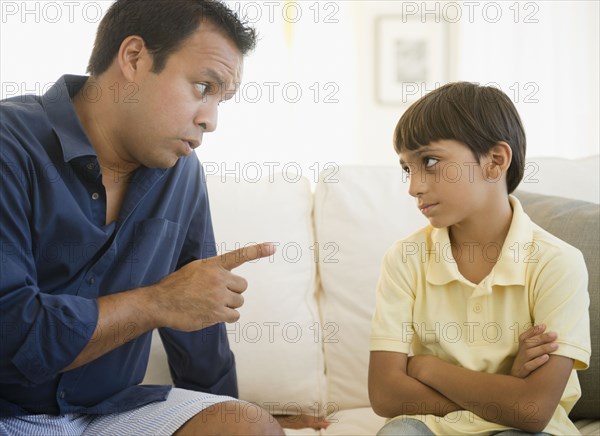 Hispanic father lecturing son