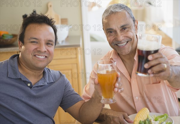 Hispanic father and son drinking