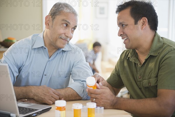 Hispanic son explaining medication to father