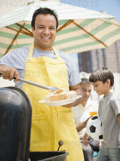 Hispanic father and son at barbecue