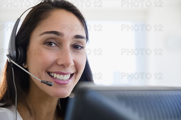 Caucasian businesswoman wearing headset at desk