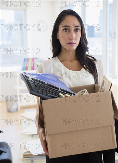 Caucasian businesswoman carrying personal items