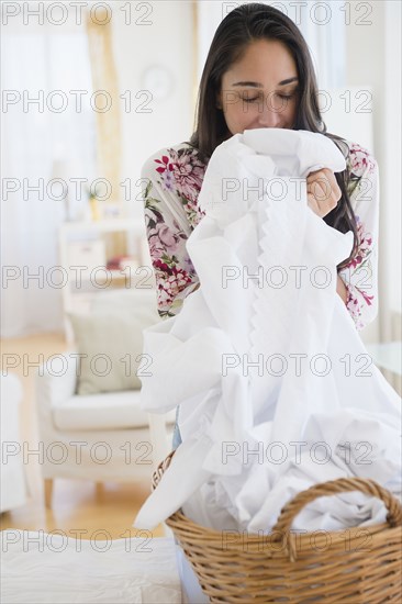 Caucasian woman smelling fresh laundry