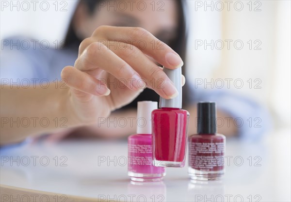Caucasian woman selecting bottle of nail polish
