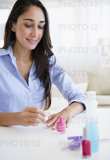 Caucasian businesswoman painting her nails